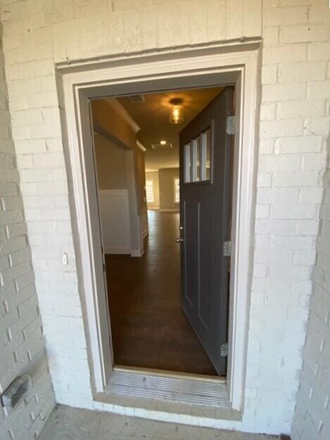 property entrance featuring brick siding