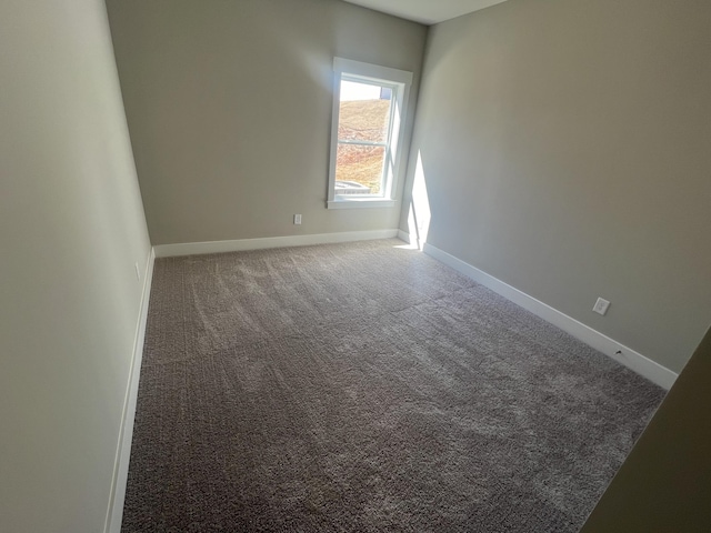 carpeted spare room featuring baseboards