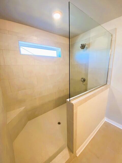 full bathroom featuring baseboards and a walk in shower