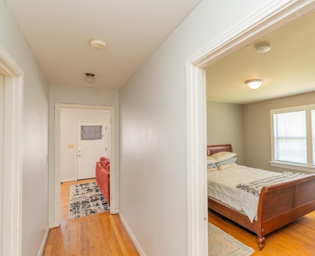 hall featuring light wood-style floors and baseboards