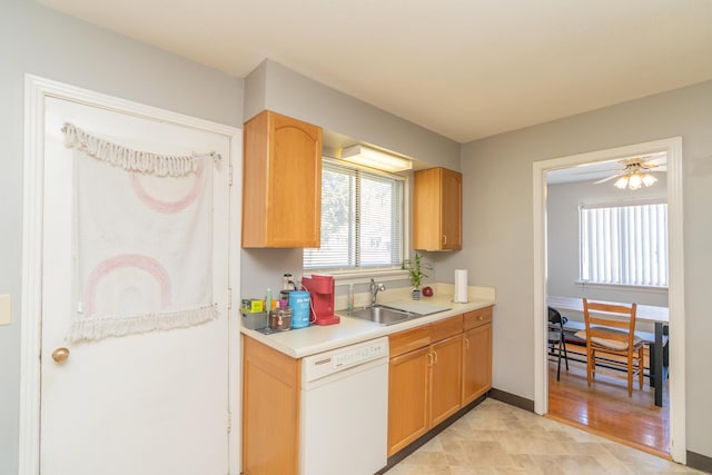 kitchen with baseboards, a ceiling fan, dishwasher, light countertops, and a sink