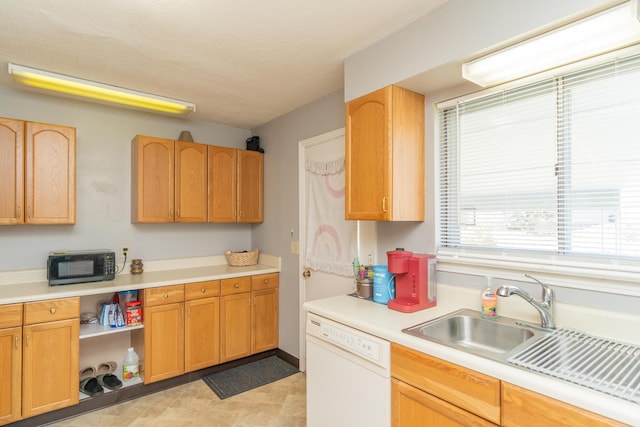 kitchen with a sink, black microwave, light countertops, and dishwasher