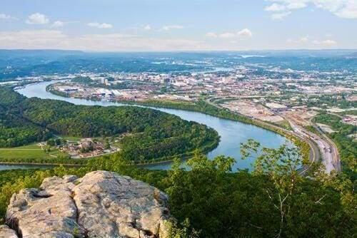 bird's eye view with a water view and a wooded view