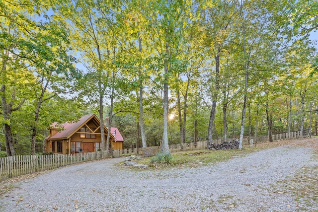 view of yard with a fenced front yard and a wooded view