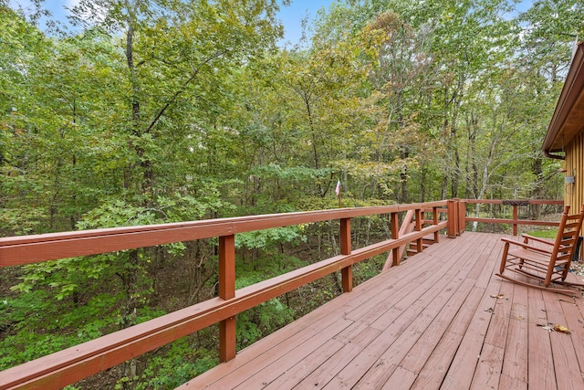 wooden terrace featuring a forest view