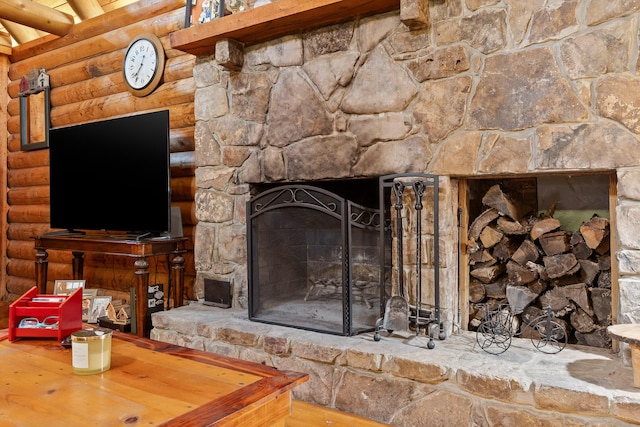 interior details featuring log walls and a stone fireplace