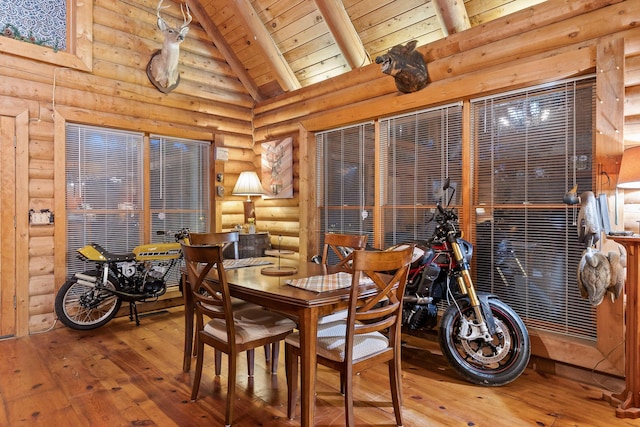 dining room with high vaulted ceiling, hardwood / wood-style floors, wooden ceiling, and log walls