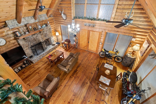 living room with vaulted ceiling with beams, ceiling fan, a fireplace, wood ceiling, and wood-type flooring