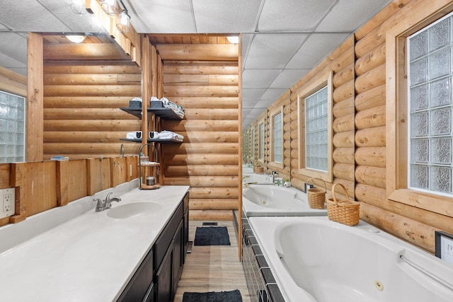 bathroom with log walls, a healthy amount of sunlight, vanity, and a whirlpool tub