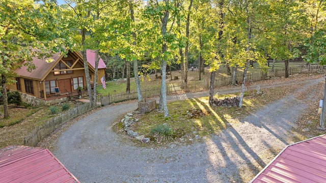 view of yard featuring dirt driveway and fence