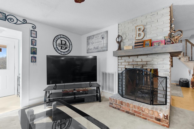 living room with carpet floors, visible vents, and a textured ceiling