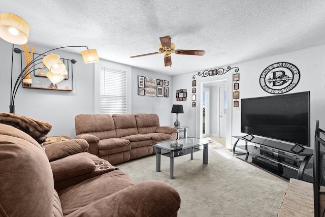 carpeted living area featuring a textured ceiling and a ceiling fan