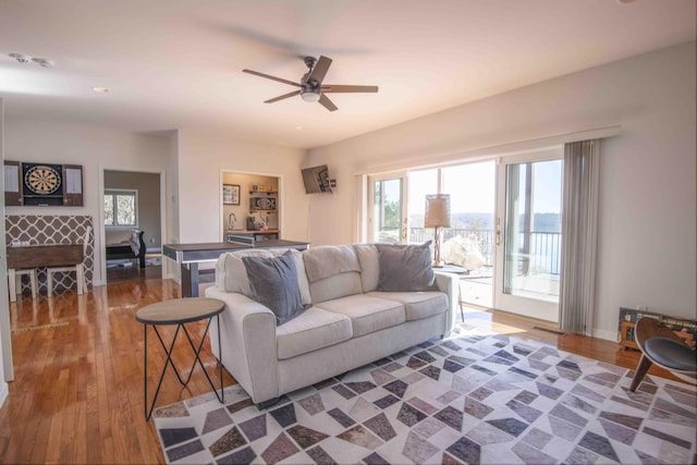 living room with ceiling fan, wood finished floors, and baseboards