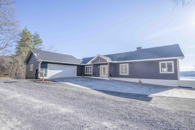 single story home with a garage, driveway, and a chimney