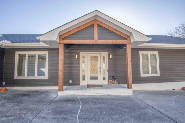 entrance to property with a shingled roof