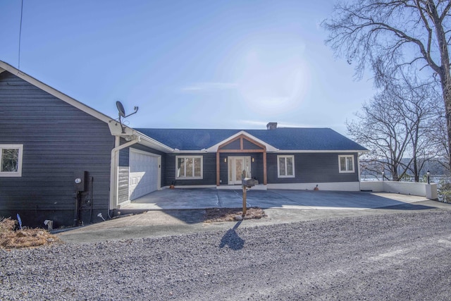ranch-style house featuring a garage and driveway