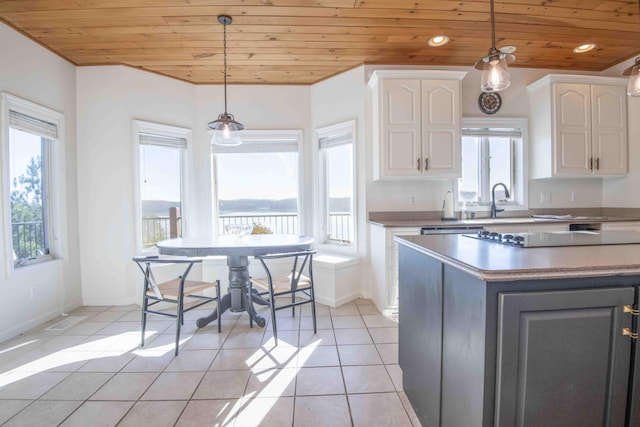 kitchen with light tile patterned flooring, wooden ceiling, recessed lighting, white cabinets, and hanging light fixtures