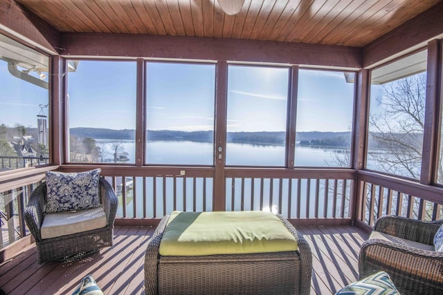 sunroom / solarium featuring wood ceiling and a water view
