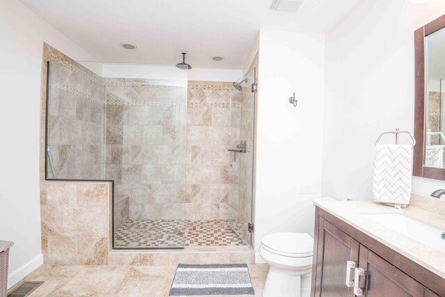 bathroom featuring toilet, vanity, a shower stall, and visible vents