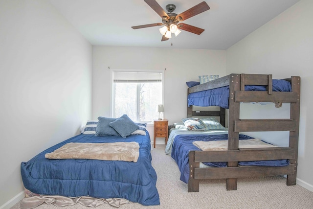 carpeted bedroom with ceiling fan and baseboards