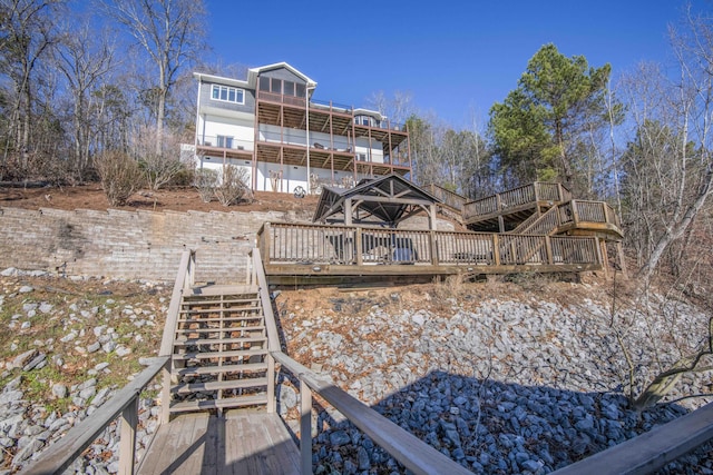 rear view of property featuring stairway and a wooden deck