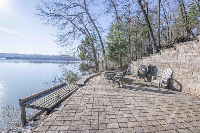 view of home's community featuring a patio area, a water view, and a fire pit