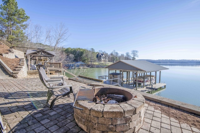 dock area featuring a fire pit, a water view, and boat lift