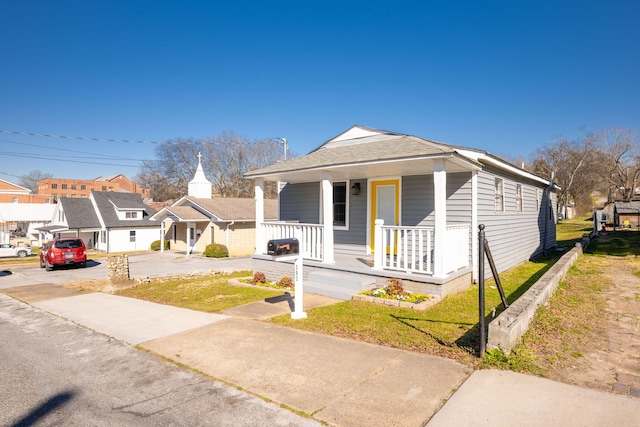 view of front of property featuring covered porch and a front lawn