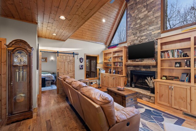 living room with wooden ceiling, a barn door, visible vents, and wood finished floors