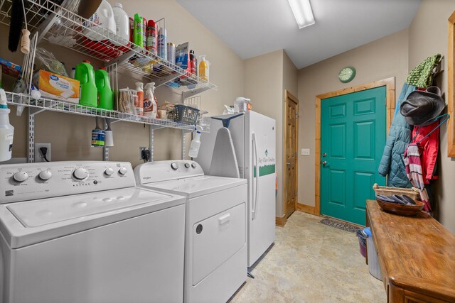 washroom featuring laundry area, washing machine and dryer, and baseboards