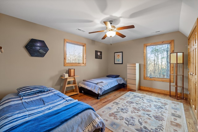 bedroom with a ceiling fan, visible vents, and wood finished floors