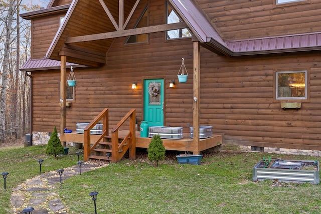 entrance to property featuring metal roof, a yard, and log veneer siding