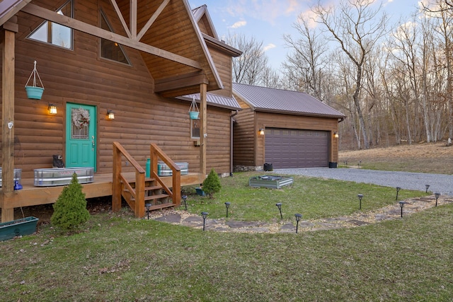 view of front of home with metal roof, an attached garage, driveway, log veneer siding, and a front yard