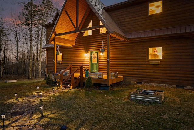 back of house at dusk with crawl space, metal roof, and a yard