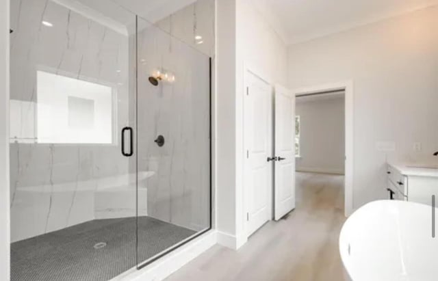 full bathroom with a freestanding bath, vanity, and a marble finish shower