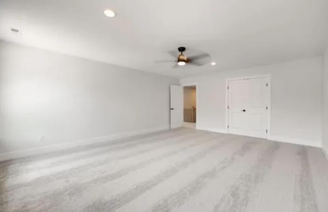 empty room with a ceiling fan, recessed lighting, baseboards, and wood finished floors