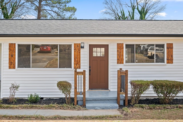 doorway to property featuring a shingled roof