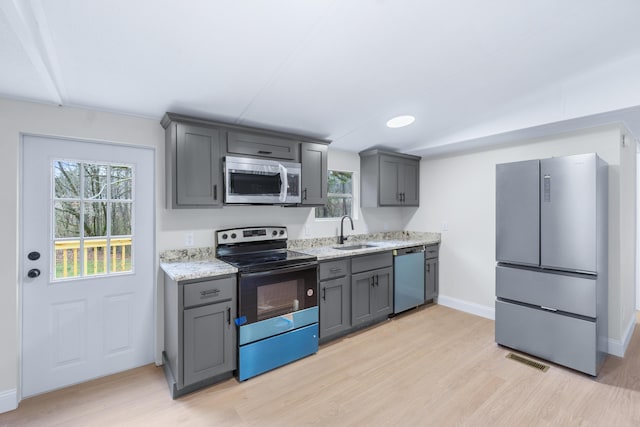 kitchen with light wood finished floors, visible vents, stainless steel appliances, and a sink