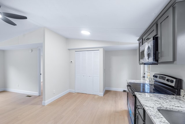 kitchen with vaulted ceiling, stainless steel appliances, gray cabinetry, and light wood-style floors