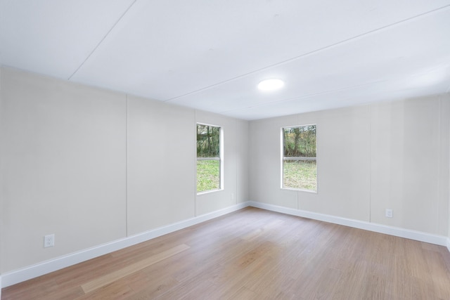 spare room with light wood-style floors and baseboards