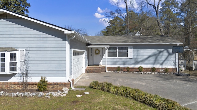 doorway to property featuring an attached garage, crawl space, and driveway