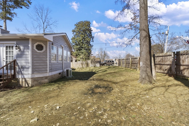 view of yard featuring cooling unit and fence