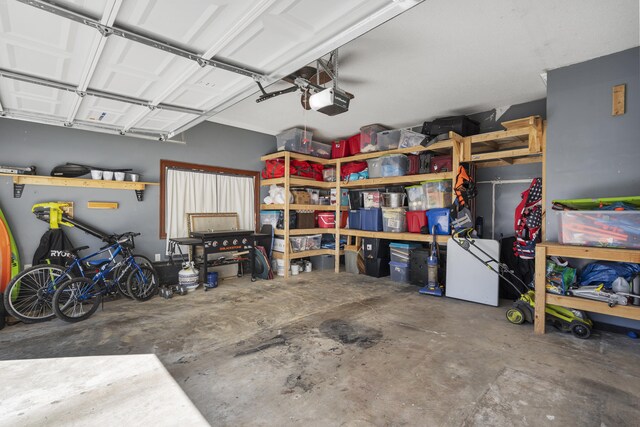 garage with a garage door opener and refrigerator