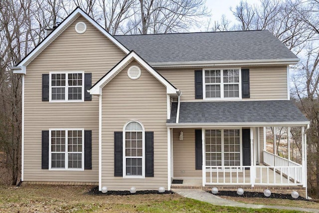 traditional-style home with a porch and roof with shingles