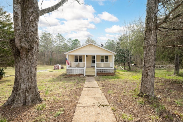 view of front of home featuring a porch and fence