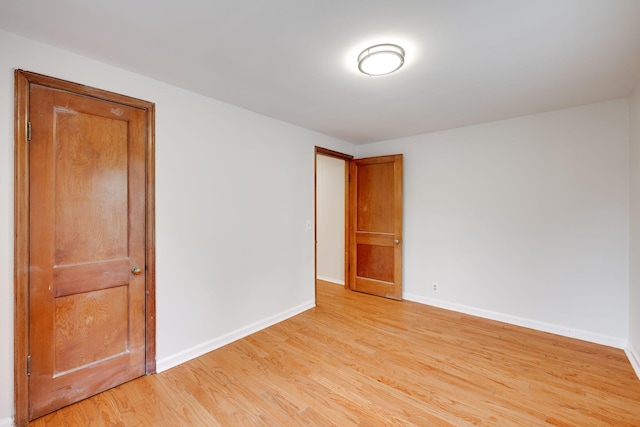 spare room featuring light wood-style flooring and baseboards