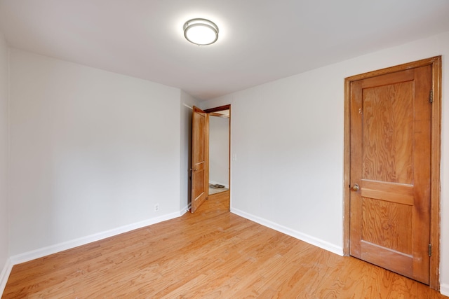 empty room featuring light wood-type flooring and baseboards