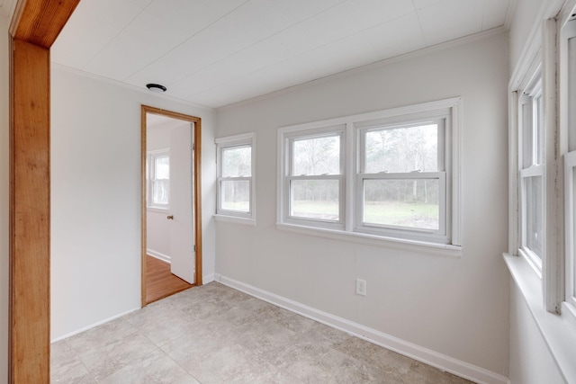 unfurnished room with baseboards and crown molding