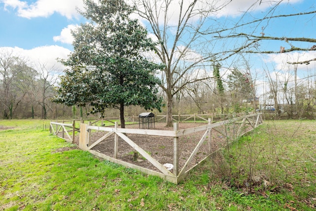 view of gate with a vegetable garden and a lawn