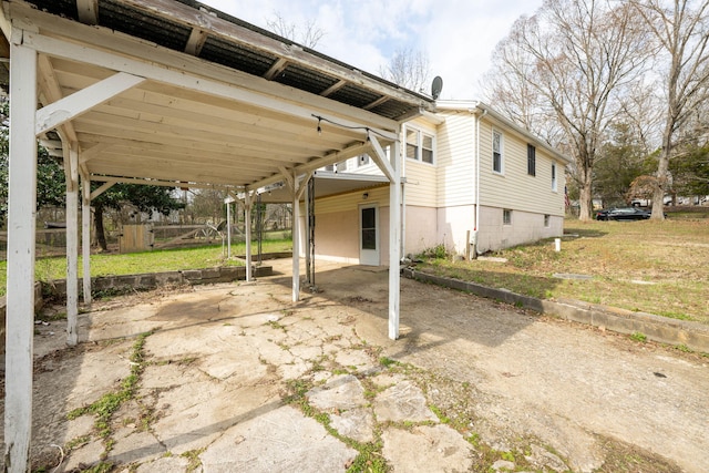 view of patio with a carport, fence, and concrete driveway